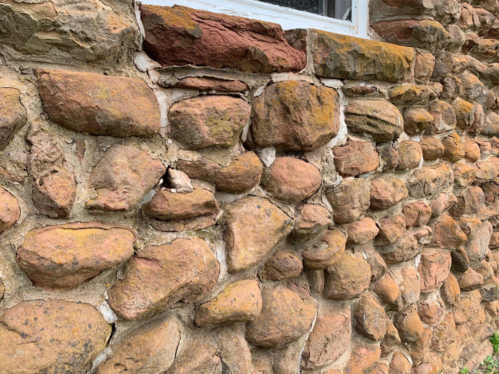Existing weathered sandstone wall at Dalvay by the Sea before heritage masonry repair