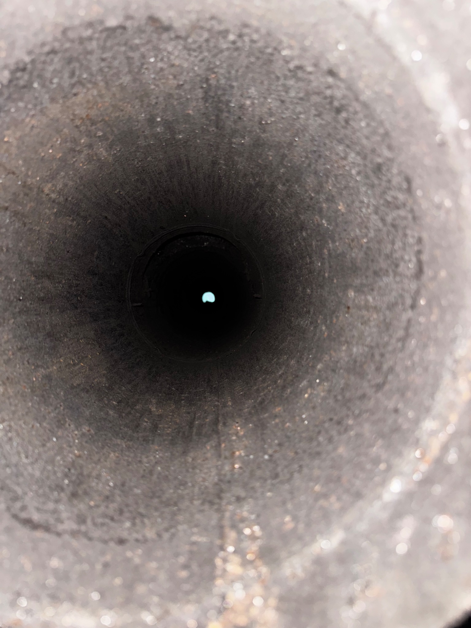 View looking up a metal chimney liner to daylight after a lightning strike