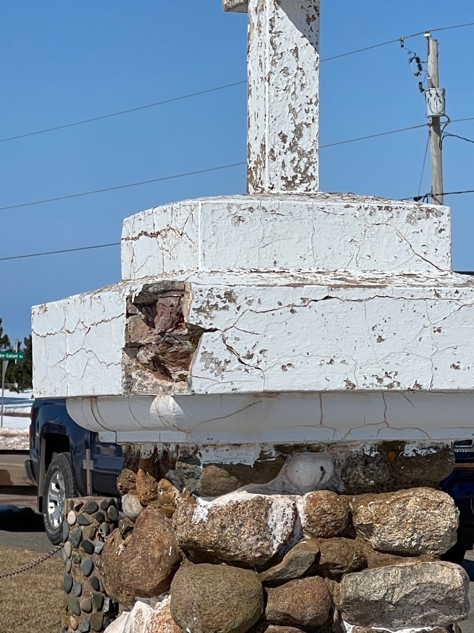 Damaged transition between fieldstone masonry and coping on a Mont-Carmel monument