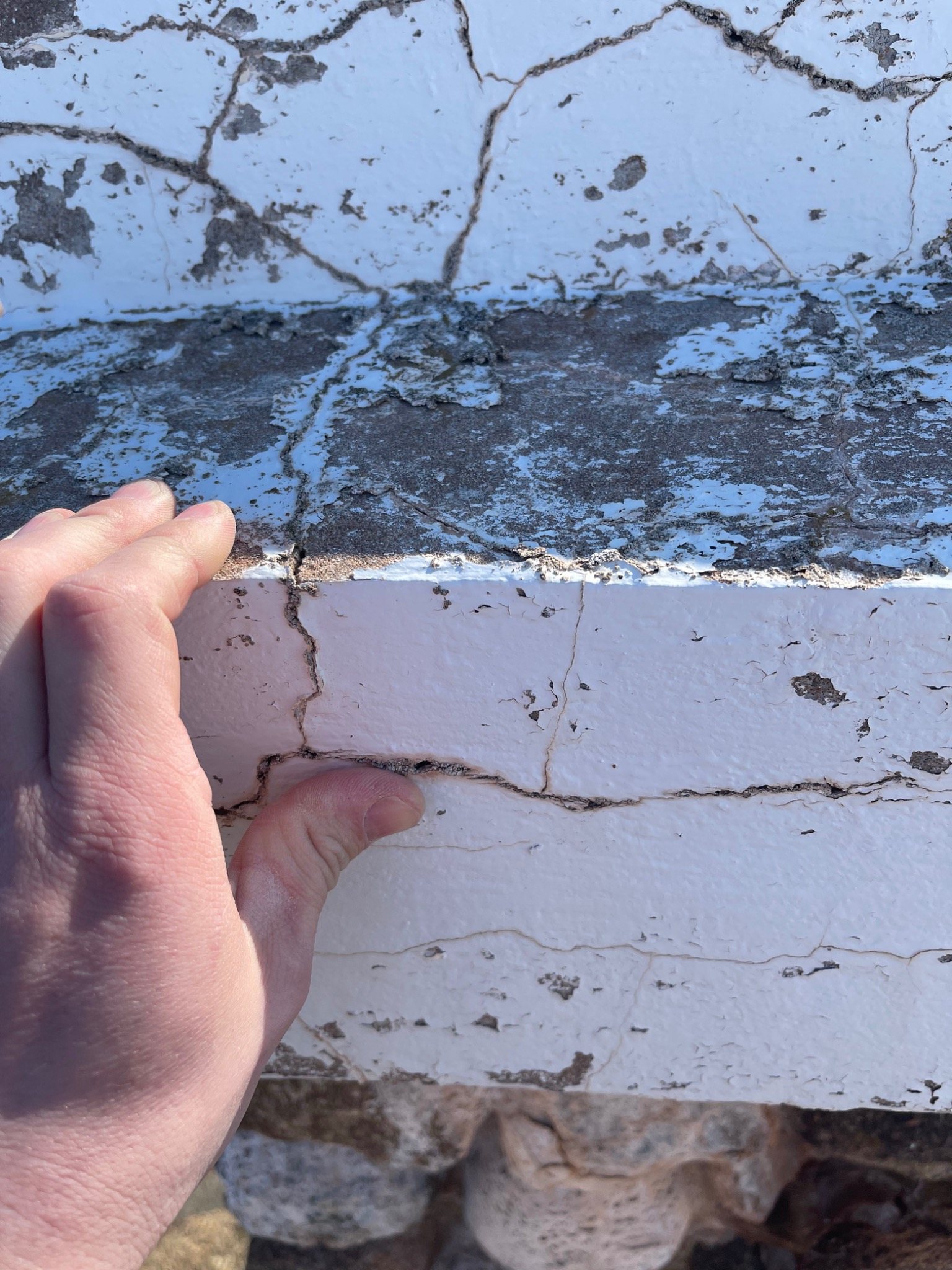 Deteriorated lime-based coping material on a Mont-Carmel stone monument