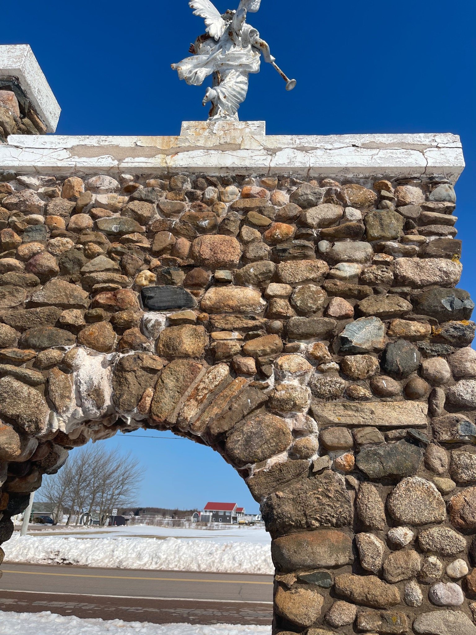 Century-old fieldstone arch monument at Mont-Carmel Church during winter