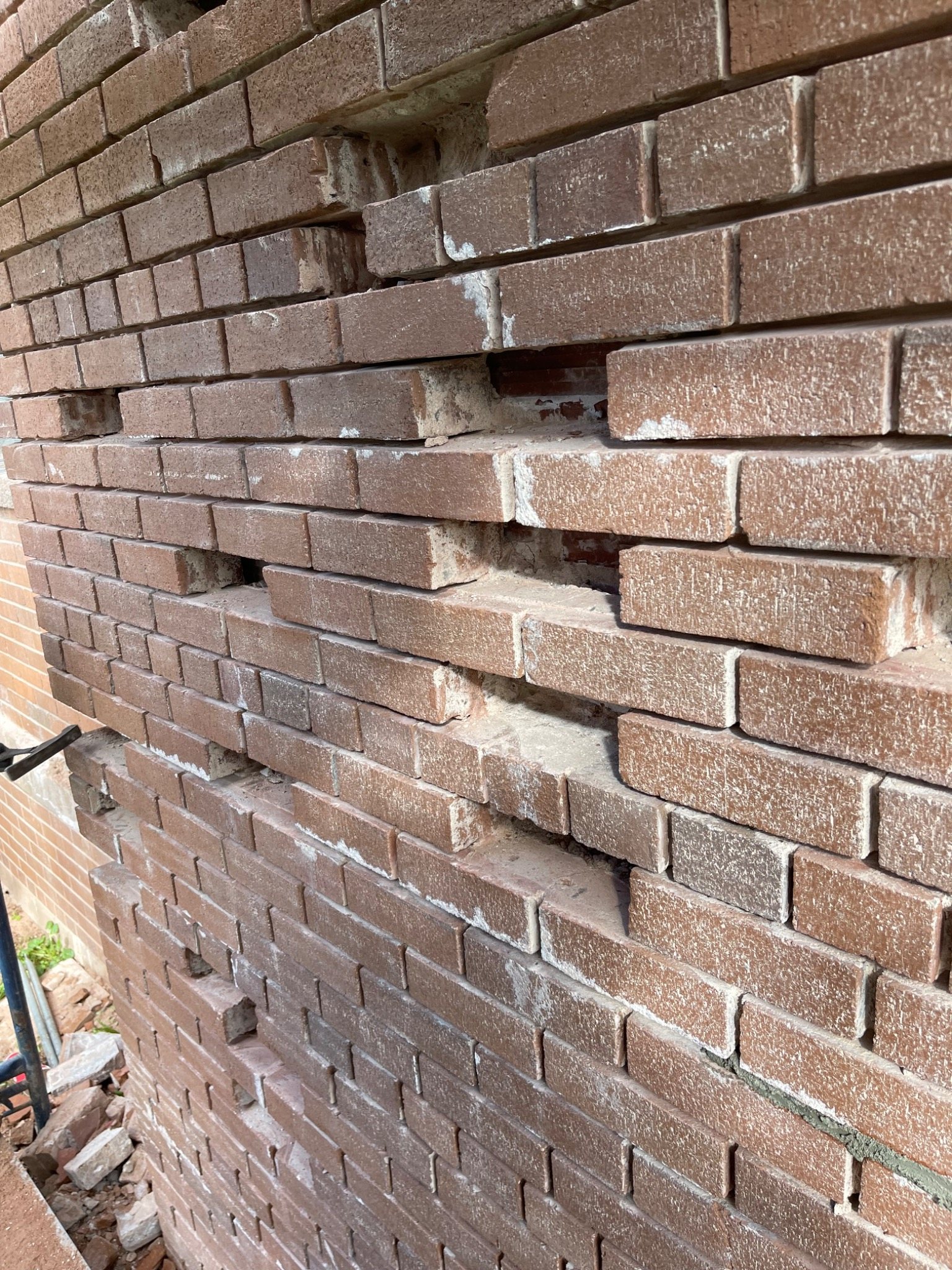 Brick masonry wall with severe outward displacement and opened joints