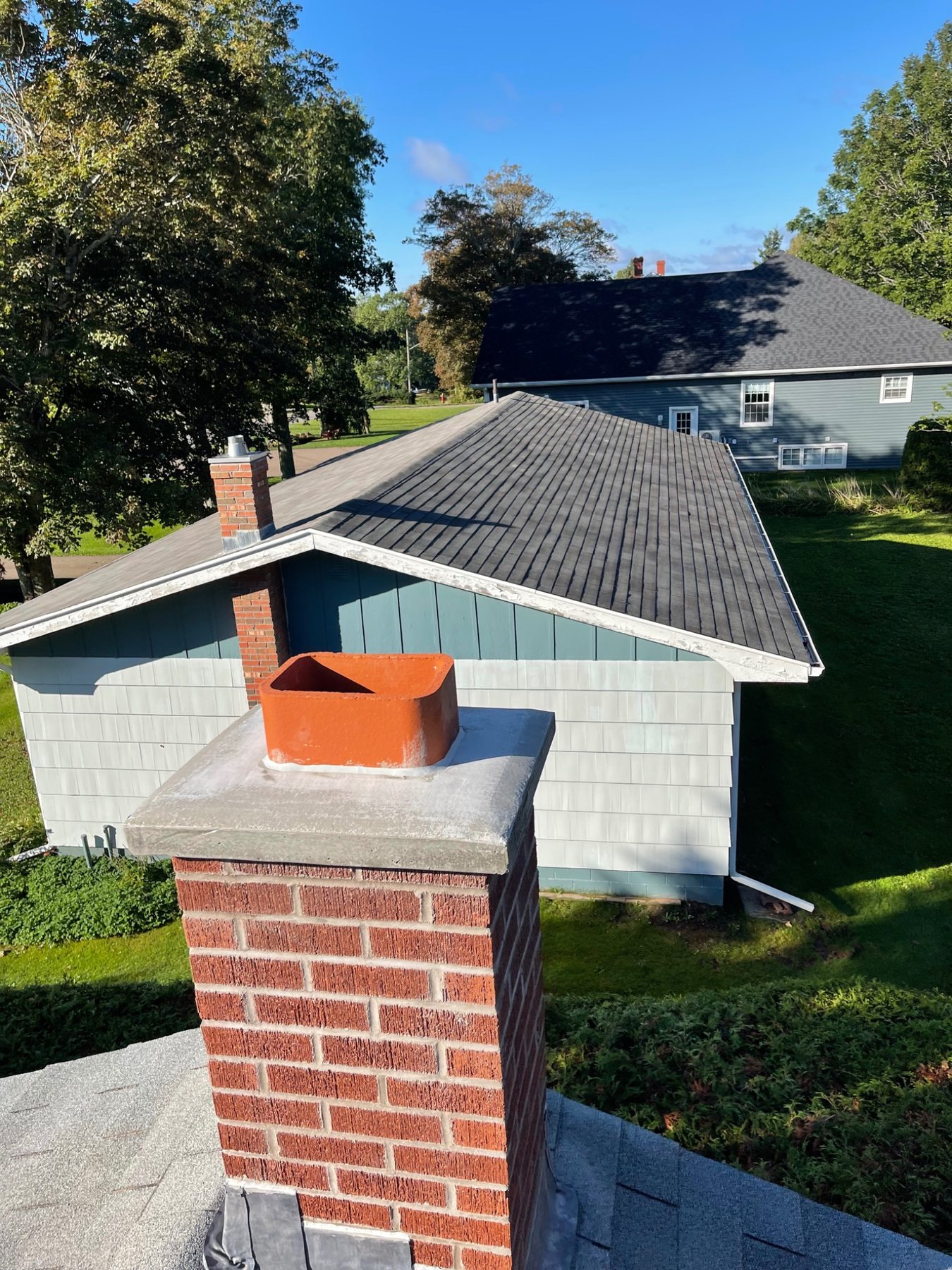 Completed brick masonry chimney with a concrete crown and exposed flue in Prince Edward Island