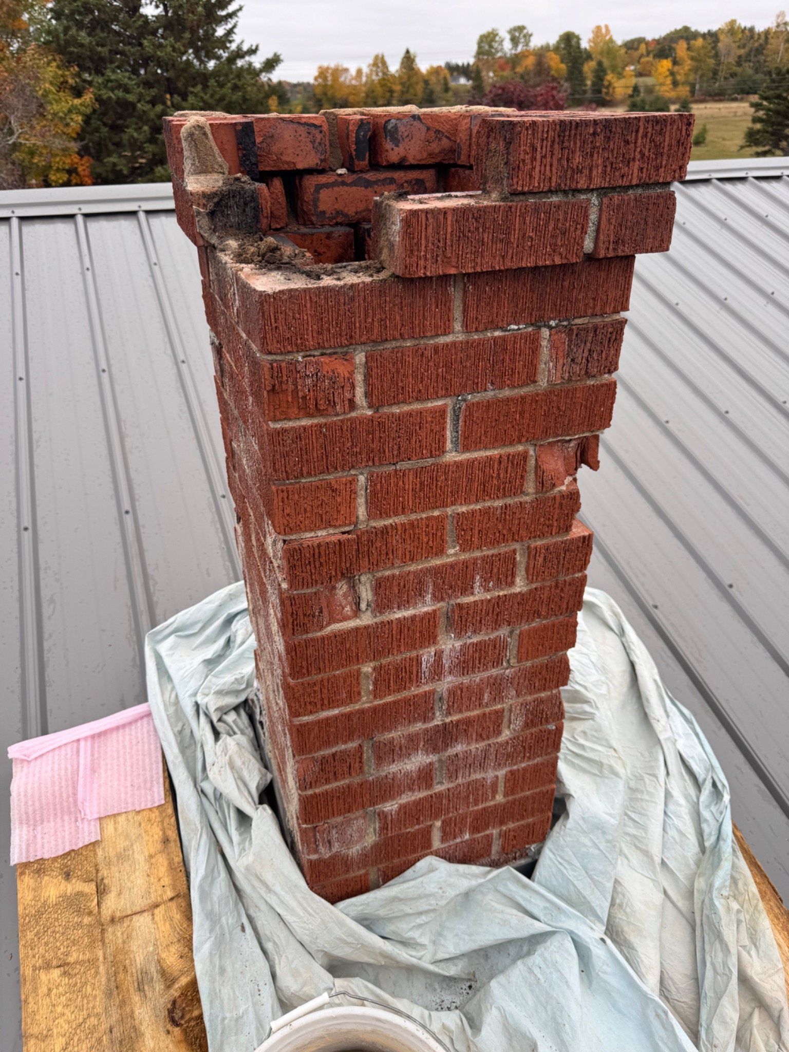 Brick chimney with severe upper-course deterioration and missing masonry