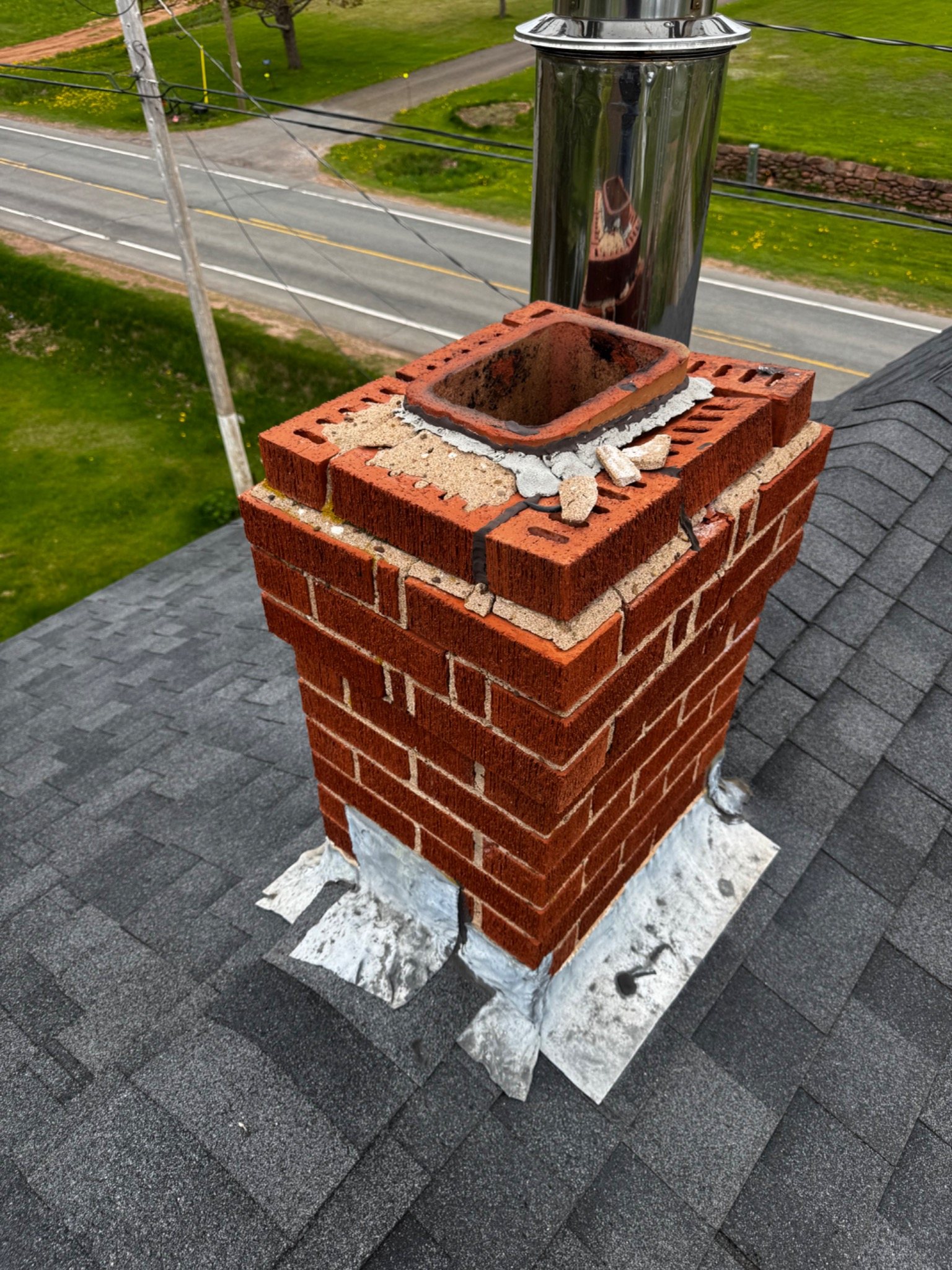Chimney repair work at roof height showing access and upper masonry conditions