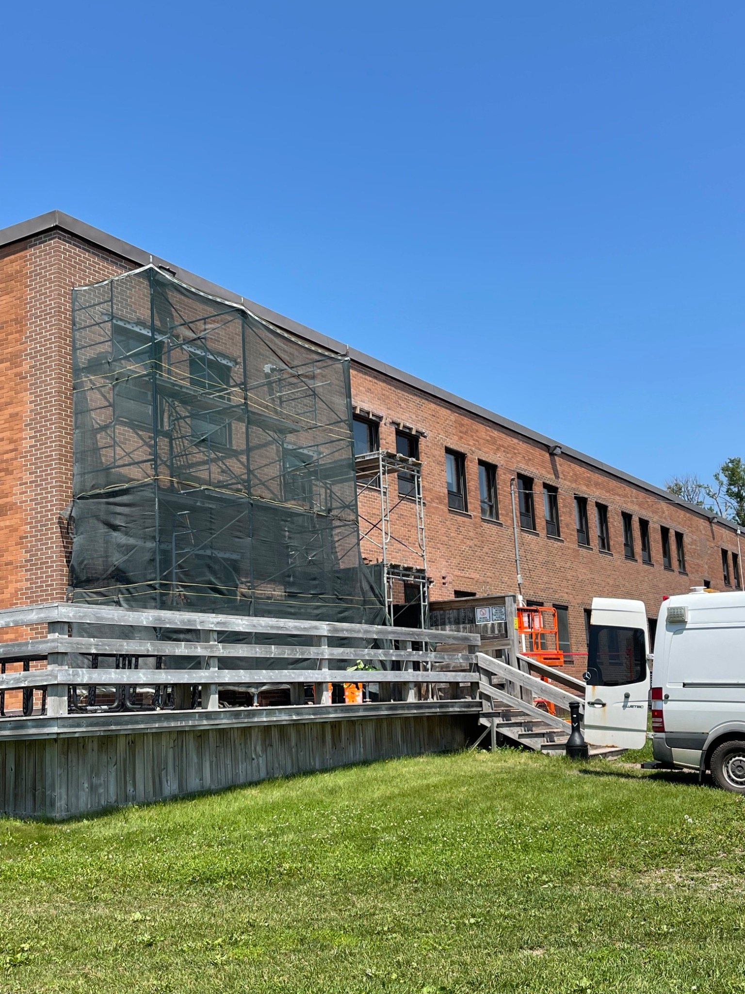 Large commercial brick building with extensive scaffolding for masonry work