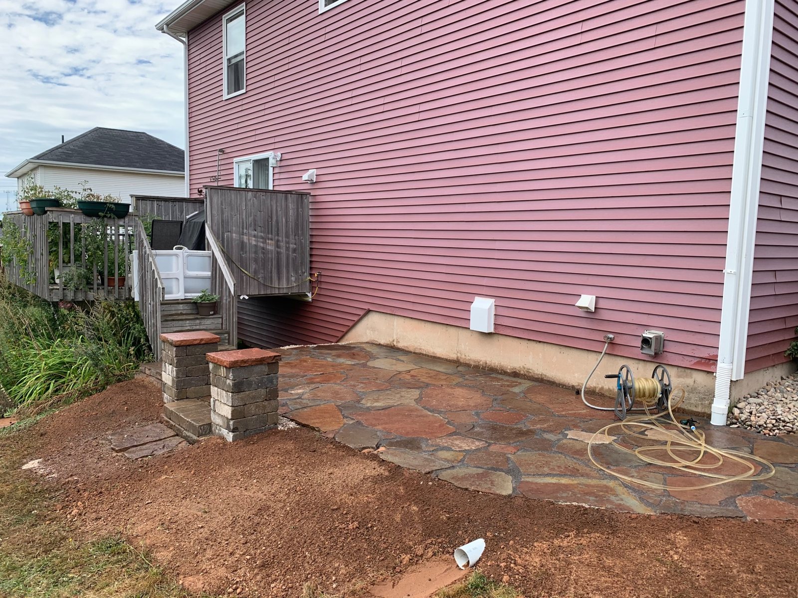 Flagstone walkway repair area showing grading and drainage conditions around the stone surface
