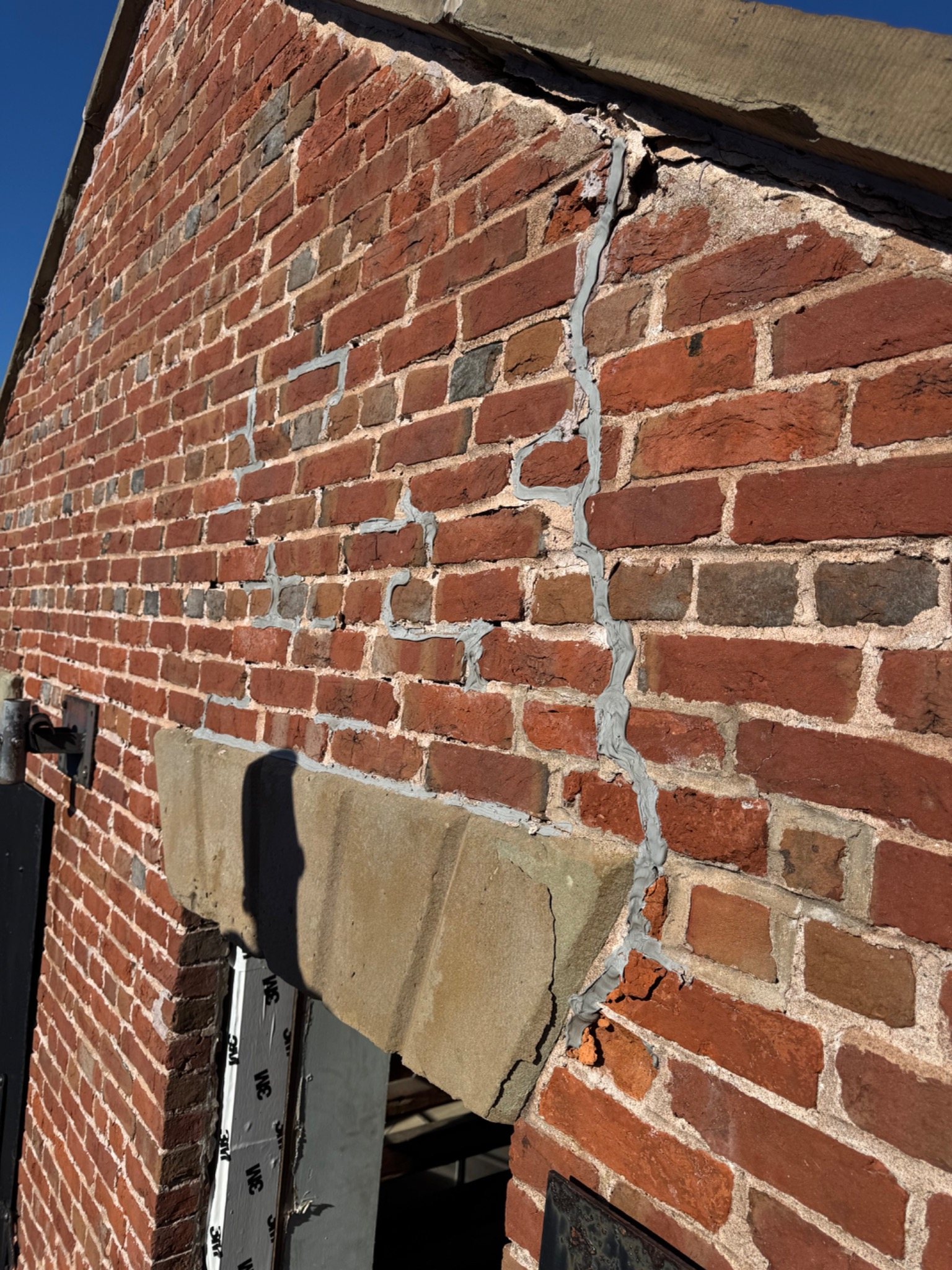 Historic brick wall with visible previous mortar repairs and patching