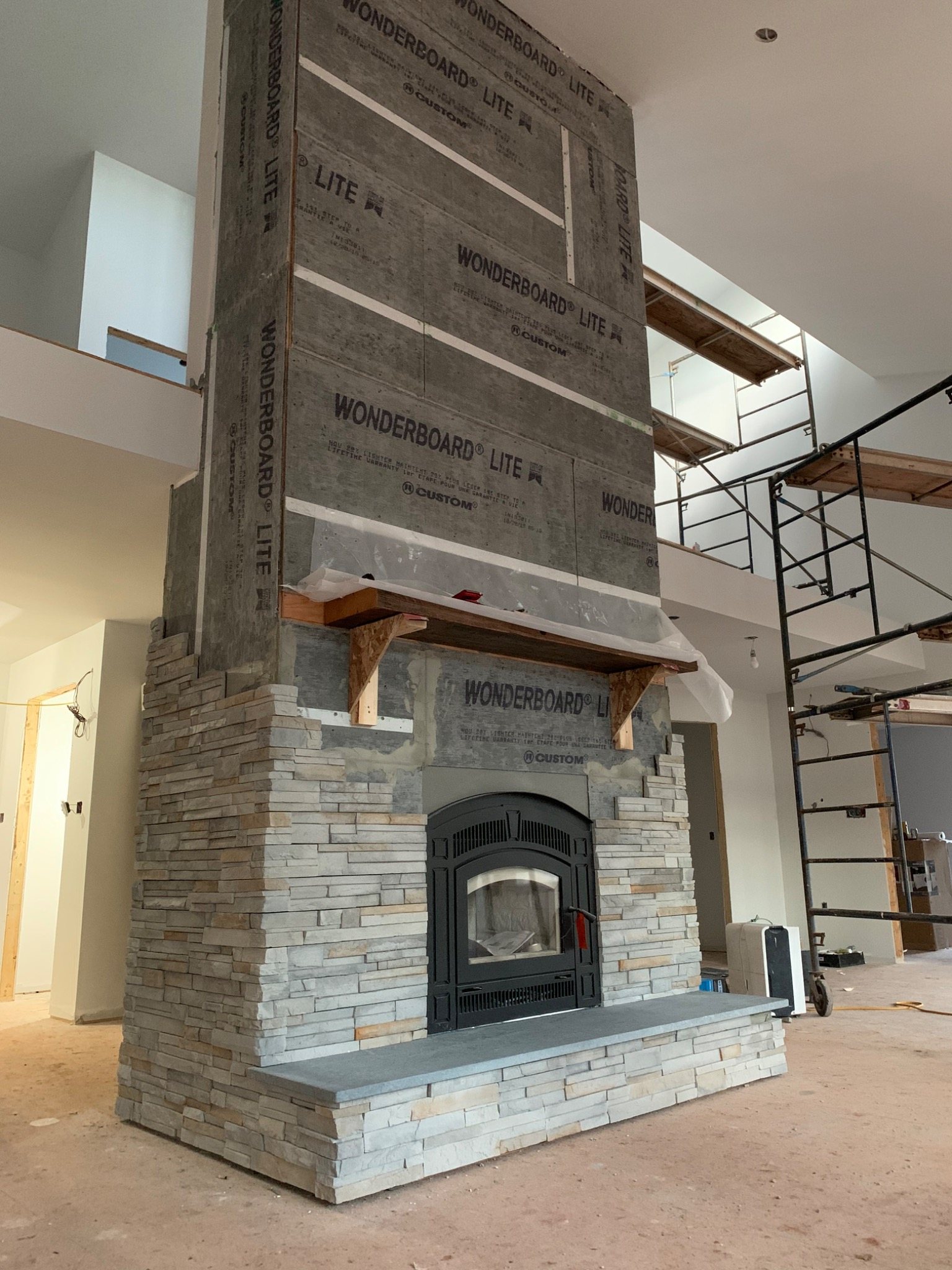 Thin manufactured stone veneer being installed over a prepared exterior wall assembly