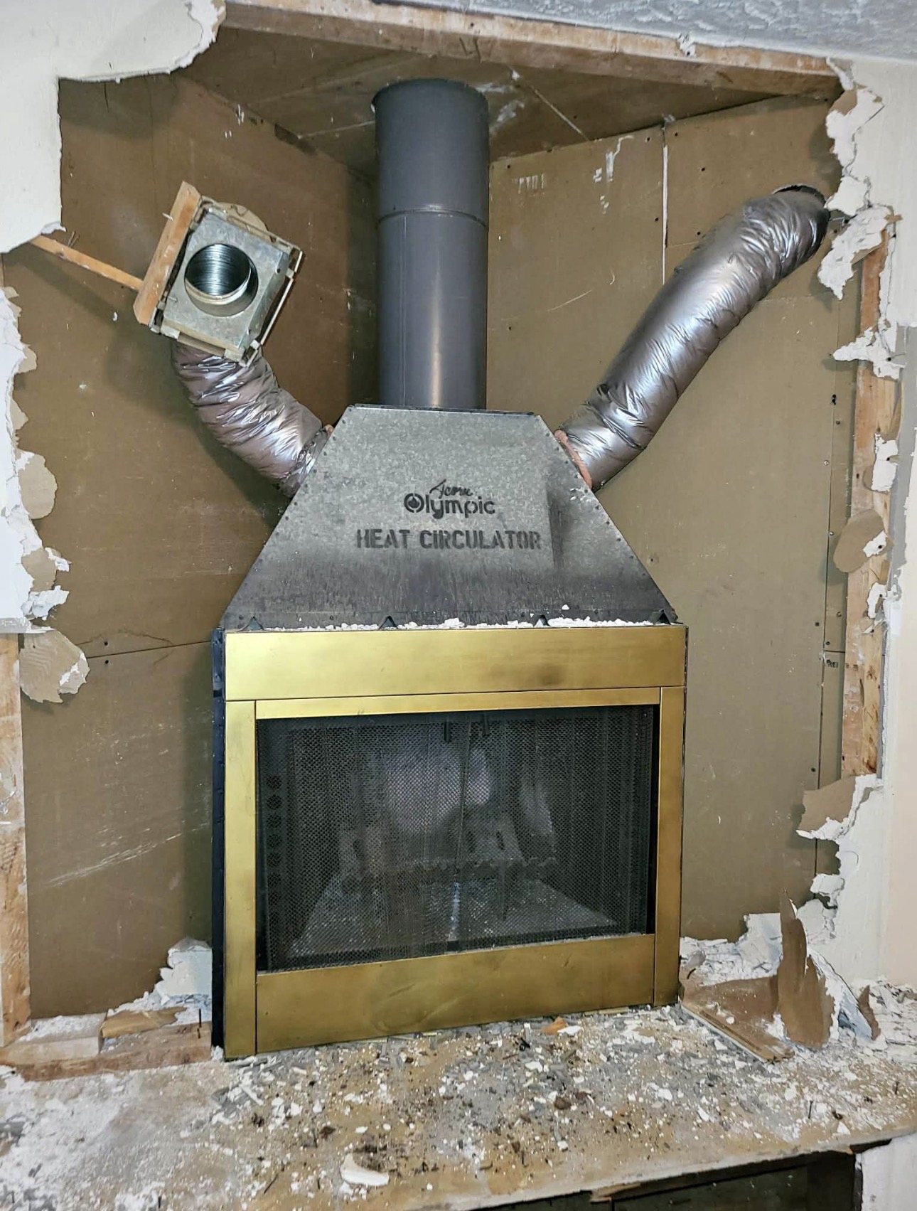 Factory-built fireplace heat circulator exposed during renovation