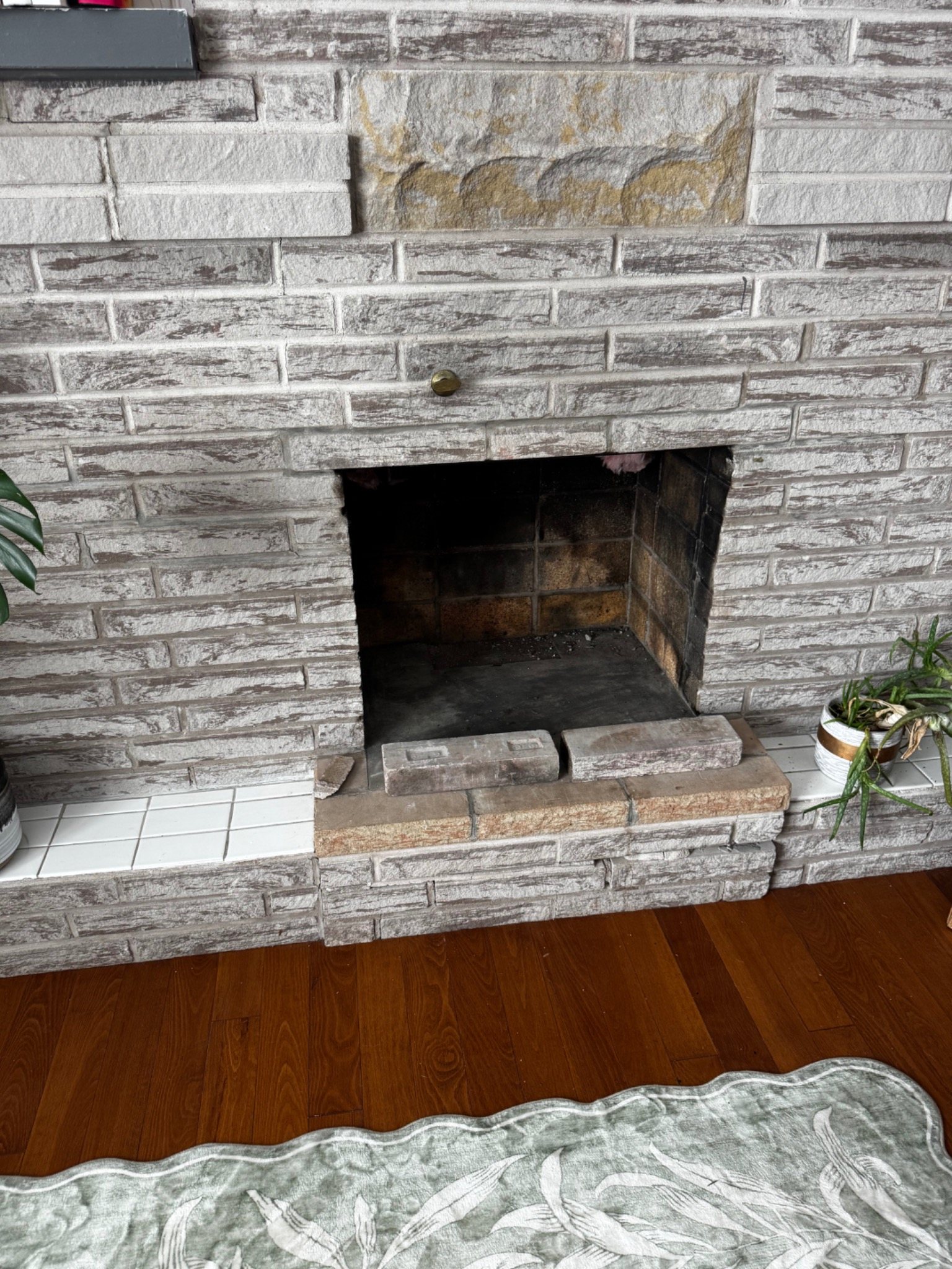 Masonry firebox with loose bricks at the hearth during repair assessment