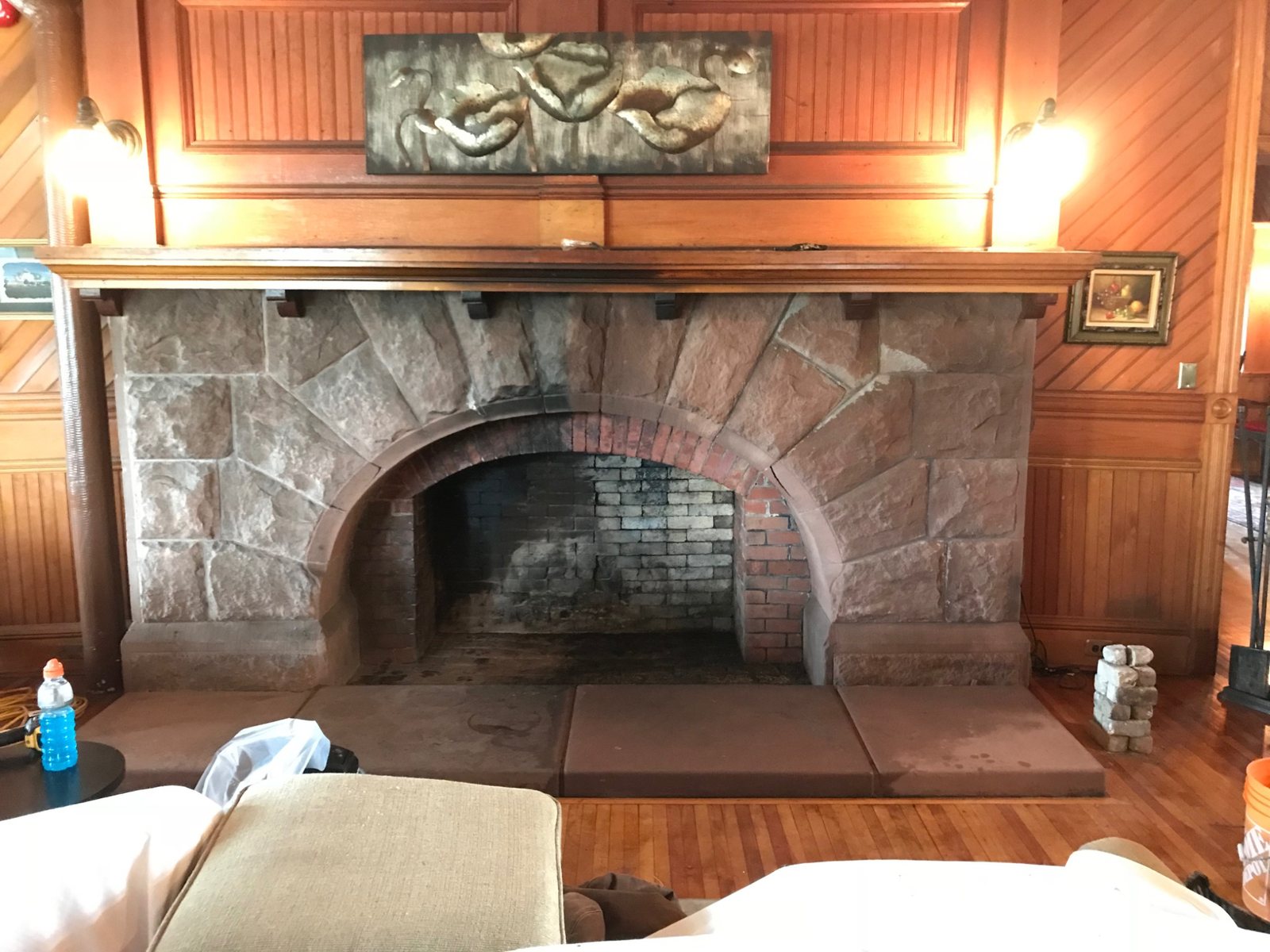 Large traditional stone and brick masonry fireplace with open firebox