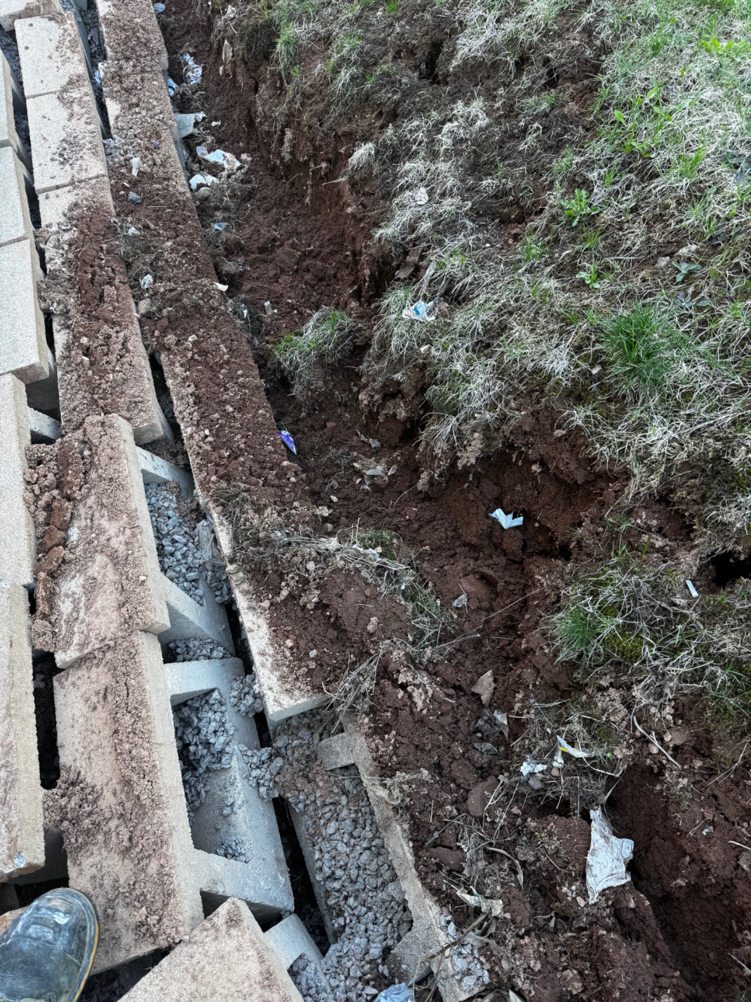 Top view of retaining wall units during failure, showing displaced coping and movement along the wall