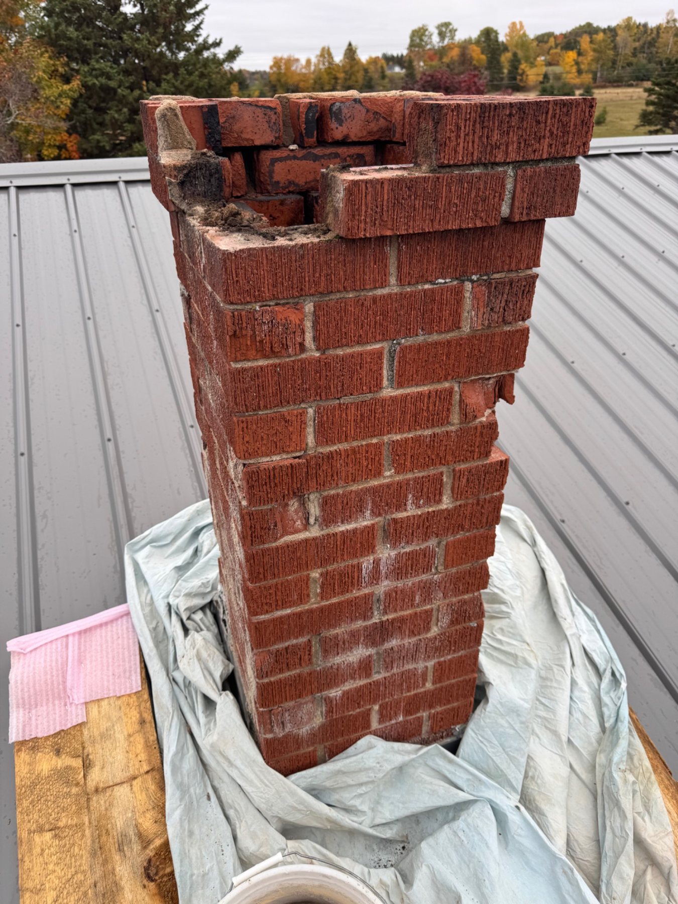 Open and missing brickwork at the top of a deteriorated PEI chimney
