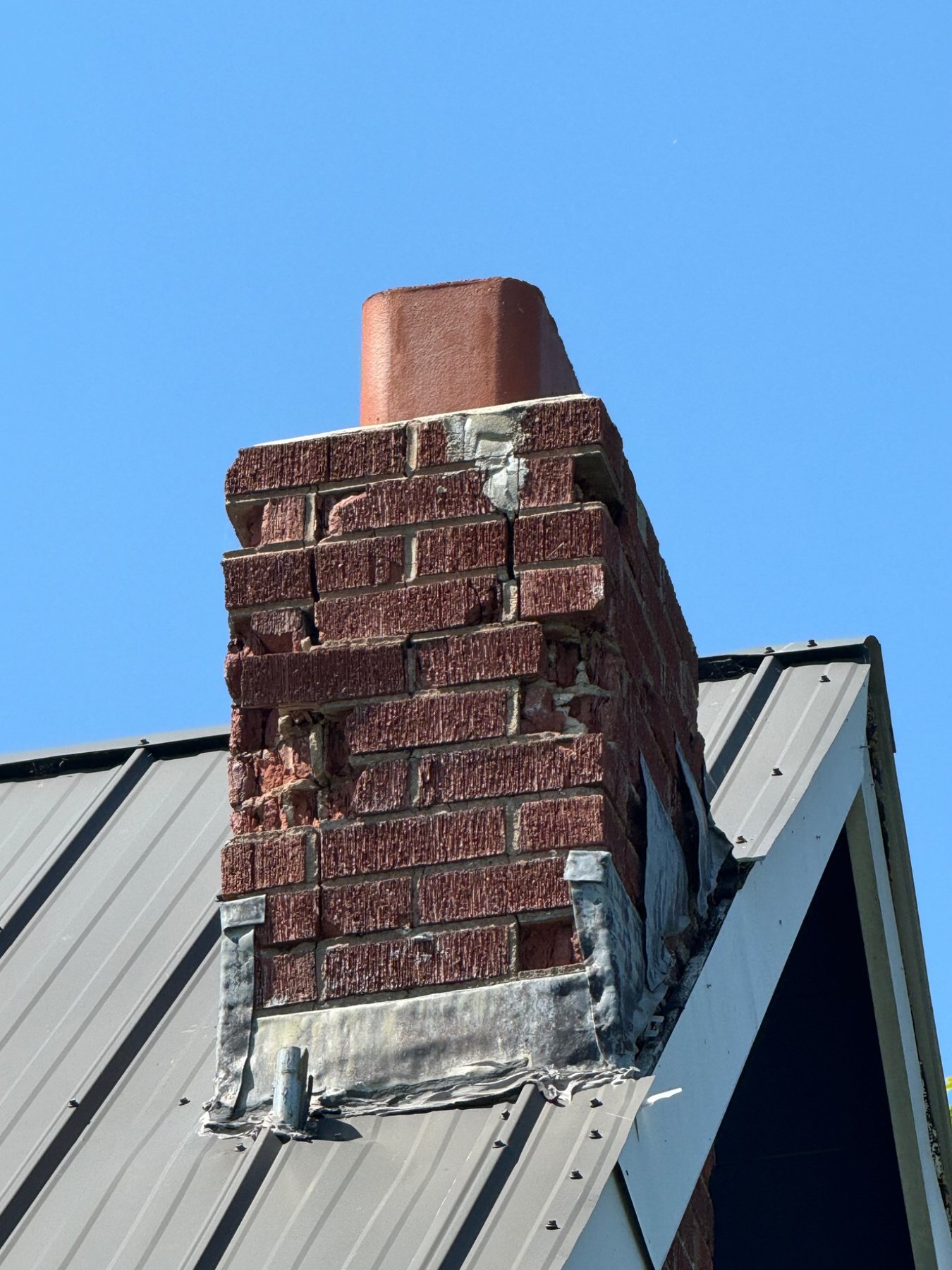 Severe brick deterioration and unit loss on a masonry chimney in Prince Edward Island