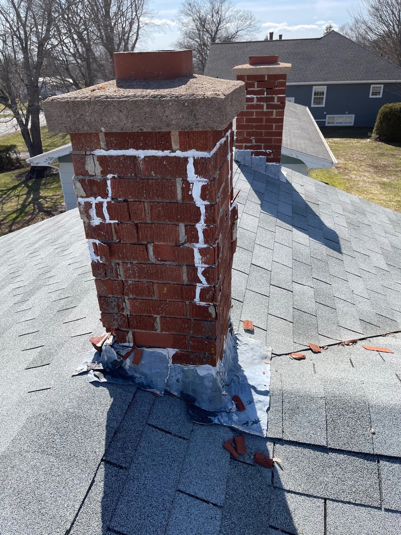 Multiple previous patching attempts visible in chimney mortar joints and flashing in PEI